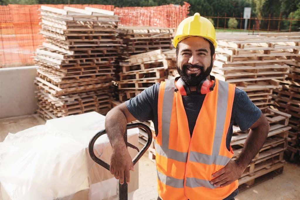 Worker smiling looking at camera after unloading pallets of inventory